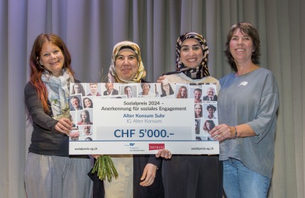 Vier strahlende Frauen halten gemeinsam und stellvertretend für den Alten Konsum einen übergrossen Check, der den Betrag von 5000 Franken zeigt. Der Check symbolisiert ihren Sieg beim Sozialpreis 2024.